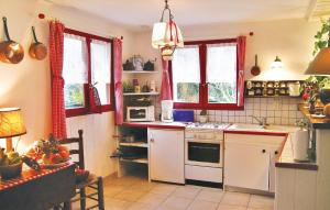 a kitchen with white appliances and red windows at Awesome Home In Bénodet With Wifi in Bénodet