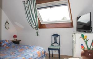 a bedroom with a bed and a window and a chair at Awesome Home In Bénodet With Wifi in Bénodet