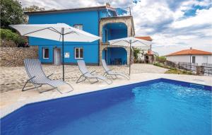 a house with a pool and two chairs and umbrellas at Beautiful Apartment In Klenovica With Kitchen in Klenovica