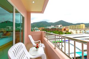 einen Balkon mit 2 weißen Stühlen und Stadtblick in der Unterkunft Phusita Hotel - SHA Certified in Patong Beach