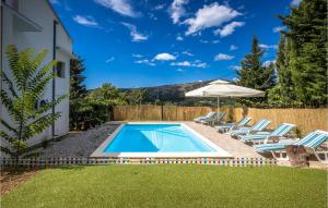 a swimming pool in a yard with chairs and an umbrella at Nice Home In Bribir With Wifi in Bribir