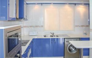 a blue kitchen with a sink and a washing machine at Amazing Apartment In La Azohía in La Azohía