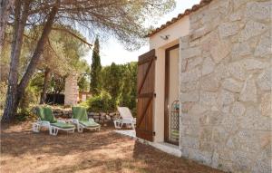 a group of chairs sitting in a yard next to a building at Three-Bedroom Holiday Home In Calcatoggio in Calcatoggio