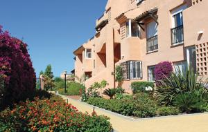 an apartment building with flowers in front of it at Awesome Apartment In Casares Costa With 3 Bedrooms, Wifi And Outdoor Swimming Pool in Casares