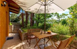 a table and chairs with an umbrella on a patio at 1 Bedroom Lovely Home In Lovran in Lovran