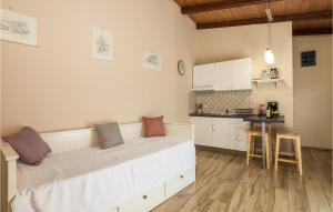 a bedroom with a white bed and a kitchen at 1 Bedroom Lovely Home In Lovran in Lovran