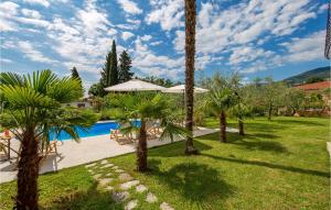 a resort with a swimming pool and palm trees at 1 Bedroom Lovely Home In Lovran in Lovran +15 photos