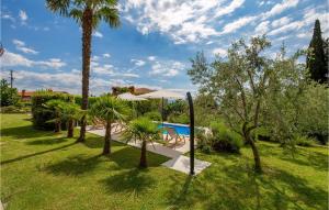 a garden with a swimming pool and palm trees at 1 Bedroom Lovely Home In Lovran in Lovran