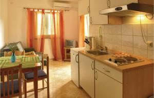 una cucina con lavandino e tavolo con piano di lavoro di Beautiful Apartment In Malinska With 1 Bedrooms And Wifi a Malinska