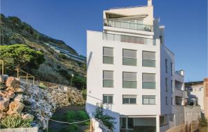ein weißes Gebäude neben einem felsigen Hügel in der Unterkunft Awesome Apartment In Casarones With Kitchen in Castillo de BaÃ±os