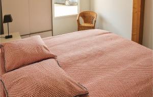 1 dormitorio con 1 cama con edredón rojo y silla en Stunning Home In Erdeven With Wifi, en Erdeven