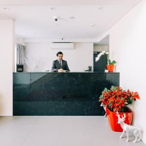 a man sitting at a counter in an office at Voyager Motel in Wallgrove