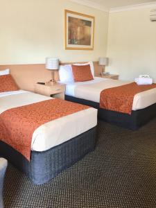 a hotel room with two beds and two lamps at Voyager Motel in Wallgrove