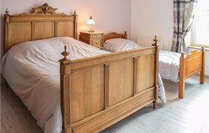 サント・メール・エグリーズにあるGorgeous Home In Sainte-mre-eglise With Wifiのベッドルーム1室(白いシーツを使用した大きな木製ベッド1台付)