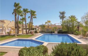 a swimming pool in a yard with palm trees at Stunning Home In Quesada-Rojales in Rojales