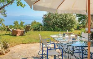einen Tisch und Stühle mit Sonnenschirm im Hof in der Unterkunft Awesome Home In Melissi Xylokastro With House Sea View in Melíssion