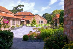 um jardim com cadeiras e um edifício de tijolos em The Ashbourne Hotel em North Killingholme