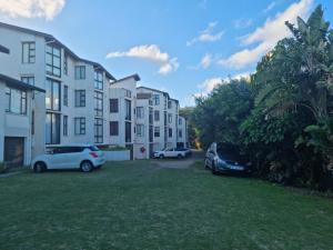 a group of buildings with cars parked in a yard at 4 LA MER, BALLITO ON THE BEACH in Ballito