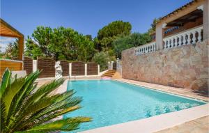 - une piscine avec un mur en pierre à côté d'une maison dans l'établissement Lovely Apartment In Bastelicaccia With Wifi, à Bastelicaccia