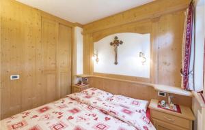 1 dormitorio con 1 cama y 1 cruz en la pared en Residence Alessandra, en Corvara in Badia