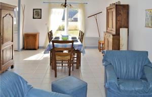un soggiorno con tavolo e divano blu di Nice Home In Clohars Carnoet With Kitchen a Clohars-Carnoët