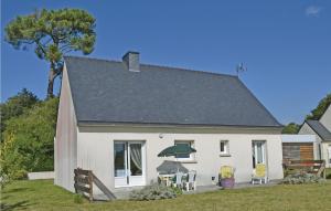 une maison blanche avec des chaises et un parasol dans l'établissement Nice Home In Clohars Carnoet With Kitchen, à Clohars-Carnoët