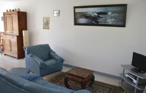 - un salon avec un canapé, une chaise et une télévision dans l'établissement Nice Home In Clohars Carnoet With Kitchen, à Clohars-Carnoët