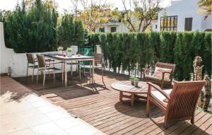 a wooden deck with a table and chairs on it at 3 Bedroom Nice Apartment In Alcossebre in Alcossebre
