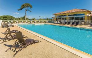 a swimming pool with chairs and a building at Les Terrasses Des Embiez in Six-Fours-les-Plages