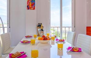 een witte tafel met een schaal fruit en sinaasappelsap bij Lovely Apartment In Manilva With Kitchen in Manilva