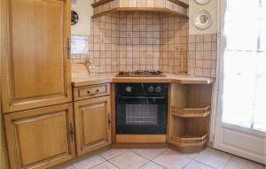 La cuisine est équipée de placards en bois et d'un four avec plaques de cuisson. dans l'établissement Awesome Home In La Tranche Sur Mer With 3 Bedrooms, à La Tranche-sur-Mer