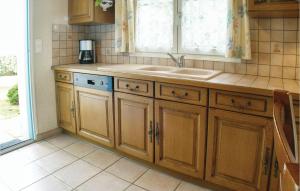 ラ・トランシュ・シュル・メールにあるThree-Bedroom Holiday Home In La Tranche Sur Merの木製のキャビネットとシンクと窓のあるキッチン