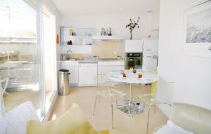 ボーケールにあるAwesome Home In Beaucaire With 2 Bedrooms And Wifiの白いキッチン(テーブル、椅子付)