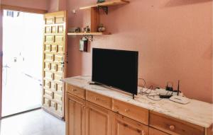 ロス・アルカサレスにあるBeautiful Home In Los Alcazares With 2 Bedroomsの薄型テレビ(室内カウンターに座る)