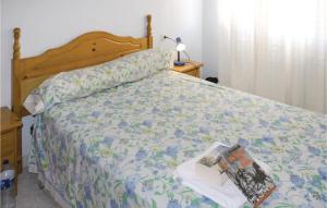 a bed with a comforter with a book on it at Two-Bedroom Holiday Home In Los Alcazares in Los Alcázares