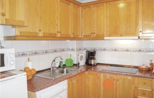 a kitchen with wooden cabinets and a sink at 2 Bedroom Cozy Apartment In Torrevieja in Torrevieja