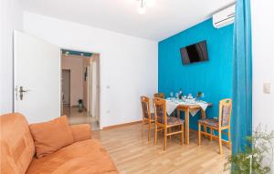 a living room with a table and a blue wall at Stunning Apartment In Crikvenica With Kitchen in Crikvenica