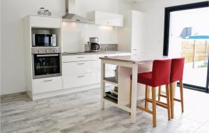 サン・ジェルマン・シュル・エにあるAmazing Home In Saint-germain-sur-ay With Wifiのキッチン(白いキャビネット、テーブル、赤い椅子付)