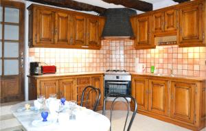 una cucina con mobili in legno, tavolo e sedie di 4 Bedroom Cozy Home In Saint Rabier a Saint-Rabier