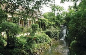 a garden with a waterfall next to a house at Stunning Home In Wimille With Kitchen in Wimille