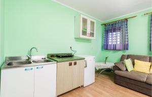 Cozy Apartment In Starigrad With House Sea View في ستاريغراد: مطبخ وغرفة معيشة مع أريكة