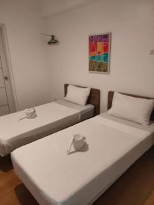 two beds in a room with hats on them at Sulit Dormitel Santa Mesa Manila in Manila