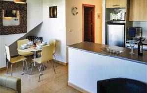 a kitchen with a table and a counter with chairs at Beautiful Apartment In Alhama De Murcia in Alhama de Murcia