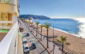 a street with palm trees next to the beach at Stunning Apartment In Lloret De Mar in Lloret de Mar