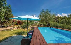 a blue umbrella sitting next to a swimming pool at Pet Friendly Home In Ledenice With Kitchen in Ledenice