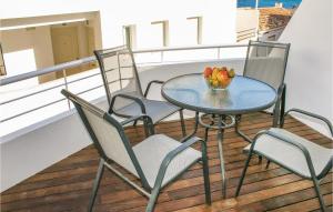 einen Tisch und Stühle auf einem Balkon mit einer Schale Tulpen in der Unterkunft Nice Apartment In Casarones With Kitchen in Castillo de BaÃ±os