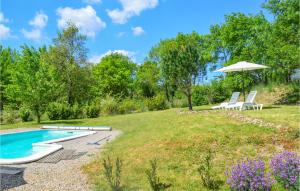 un cortile con piscina e due sedie e ombrellone di Cozy Home In Le Poujol Sur Orb With Private Swimming Pool, Can Be Inside Or Outside a Le Poujol-sur-Orb