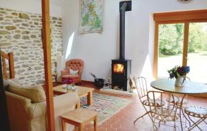 a living room with a fireplace and a table and chairs at Beautiful Home In Tregunc With 1 Bedrooms And Wifi in Trégunc