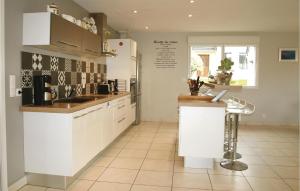 a kitchen with white cabinets and a tile floor at Holiday Home Rue Sainte-Anne in Trélévern