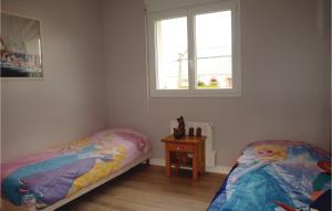 a bedroom with two beds and a table and two windows at Holiday Home Rue Sainte-Anne in Trélévern +17 photos